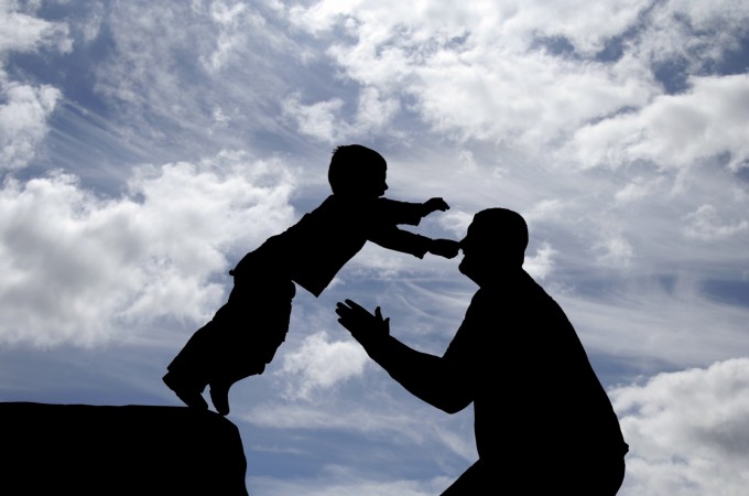 Photo de deux personnages en ombre qui représente un enfant qui saute dans les bras d'un adulte qui lui fait confiance