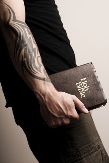 Un bras tatoué portant un Bible