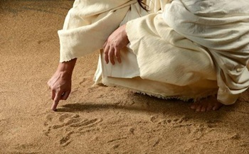 Jésus écrit calmement dans le sable