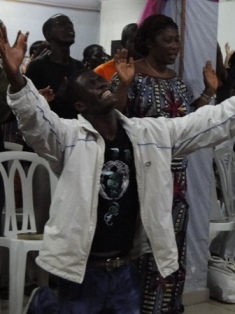 un jeune homme  crie sa louange à Dieu à  Abidjan